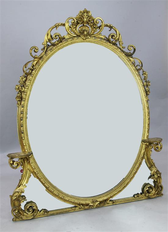 A large rococo style carved giltwood oval overmantel mirror, W. 4ft 1in. H. 5ft.